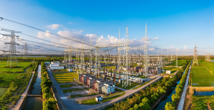 Ein Umspannwerk in einer ländlichen Umgebung. Zahlreiche Hochspannungsmasten und Stromleitungen durchziehen die Landschaft