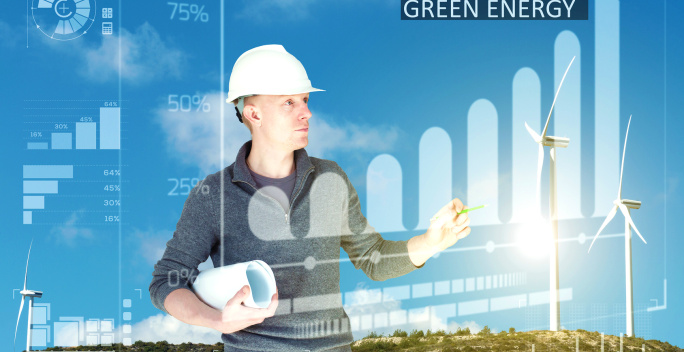 Das Bild zeigt einen Mann, der einen Schutzhelm trägt und in der Hand eine zusammengerollte Bauzeichnung hält. Im Hintergrund sieht man einen klaren blauen Himmel mit einigen Wolken sowie mehrere Windräder auf einer hügeligen Landschaft.