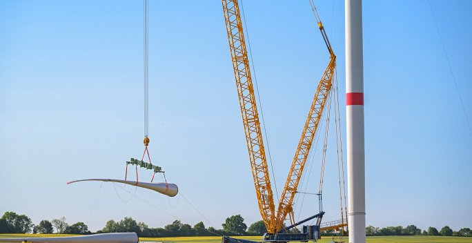 Ein Rotor einer WKA wird von einem Krank angehoben.