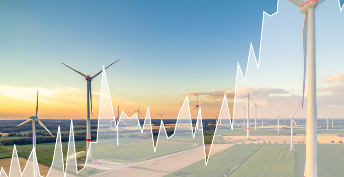 Ein Foto von einem Windpark überlagernd, ist ein transparentes Kurvendiagramm zu sehen.