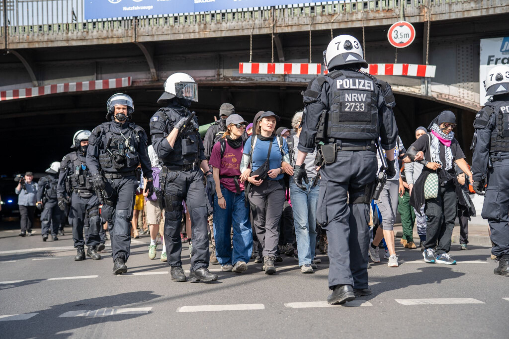 Polizisten schirmen Demonstranten bei einer Versammlung ab.