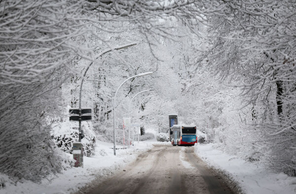 Ein Linienbus fährt durch eine verschneite Hamburger Straße. (Archivbild)