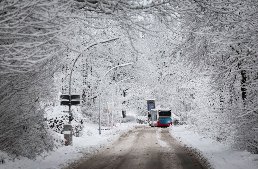 Ein Linienbus fährt durch eine verschneite Hamburger Straße. (Archivbild)