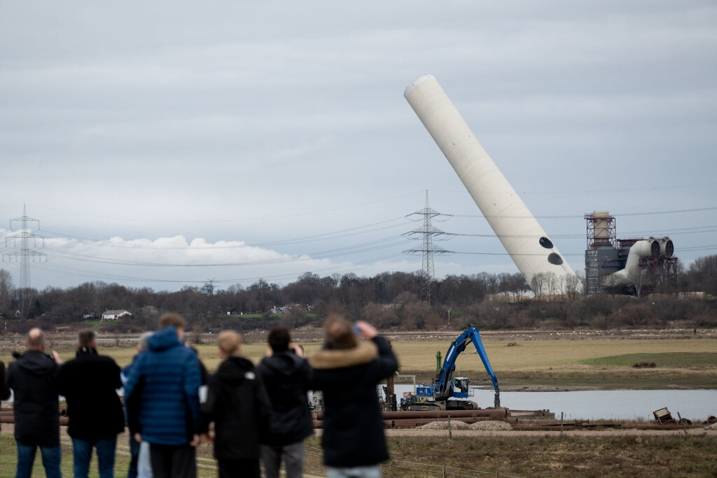 Der 180-Meter-Kamin kippt nach der Sprengung langsam um.